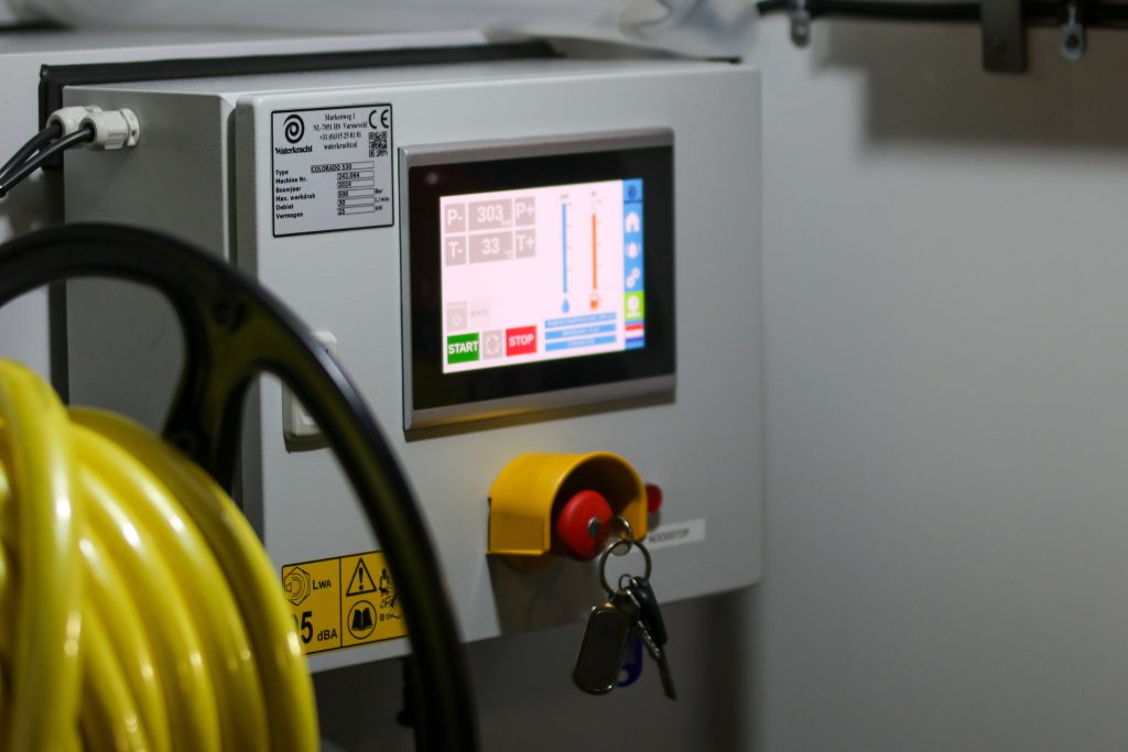 Close-up of an industrial control panel displaying safety features and a digital screen.